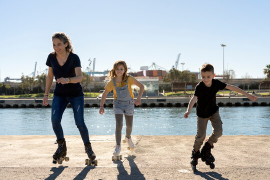 Cheerful female with kids smiling and roller skating