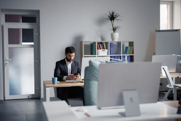 Broker using smartphone during work in cozy office
