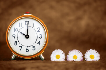 Retro alarm clock and daisy flowers. Good morning, wake up, time background with copy space.