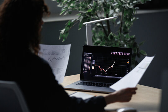 Faceless woman reading financial reports 