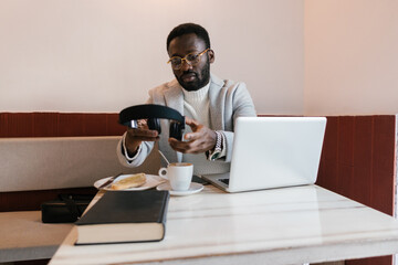 Black man with headphones at table with laptop