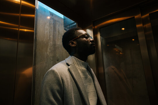 African American man in dark lit lift