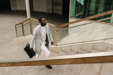 Black businessman walking upstairs of office