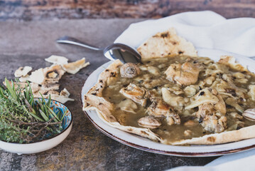 Gazpacho manchego dish. Hot stew with bushmeat, snails and flat bread from Spain