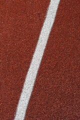 detail of the red tartan surface with white line, sporting terrain, life of the athlete