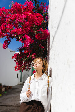 Girl leaning against the wall sunbathing