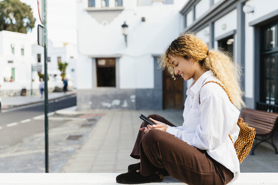 Smiling woman using smartphone outdoors