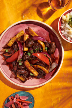 Lomo Saltado, Wok-fried beef tenders, papas fritas, onions, tomatoes, rice