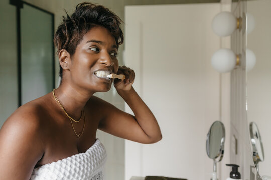 Woman cleaning her teeth in a modern bathroom