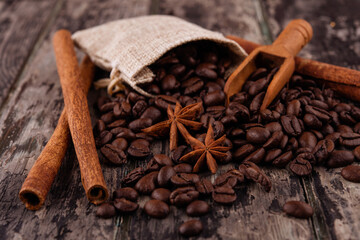 chocolate, cinnamon sticks  and coffee beans on wooden background