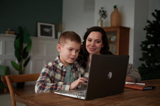 Mother helping boy doing homework