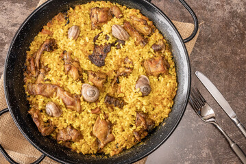 Flat Lay of a rice paella with bush meat and snails.