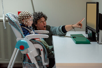 Researcher making neural study on kid in EEG cap