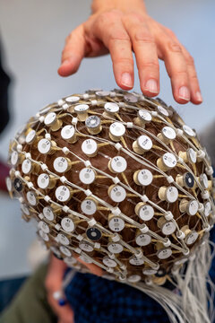 Researcher putting EEG cap on head of kid