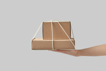 Woman holding on palm two cardboard boxes