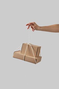 Woman holding cardboard boxes tied with string