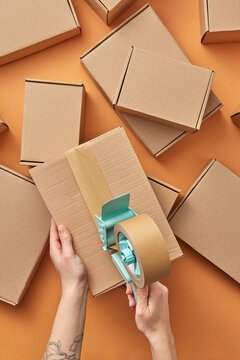Woman packing boxes for delivery with scotch