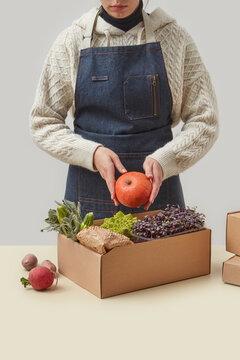 Delivery service worker packing vegetables in box