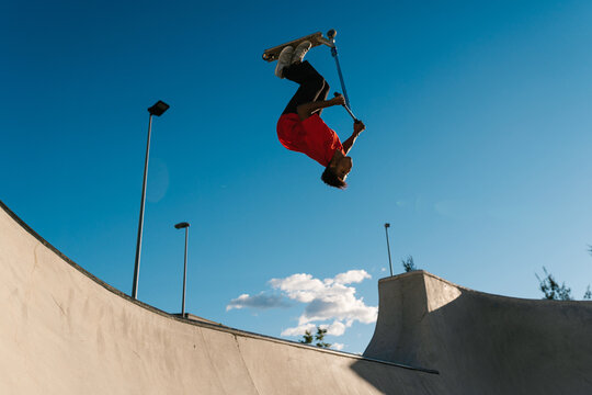 Colombian guy doing somersault on scooter on ramp