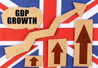 On the flag of Great Britain, a growth chart and a cardboard plate with the inscription - GDP growth