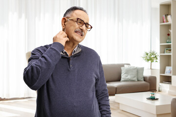 Mature man itching his neck at home