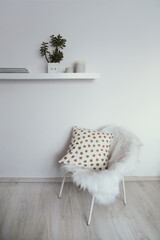 white armchair against a white wall in a modern interior