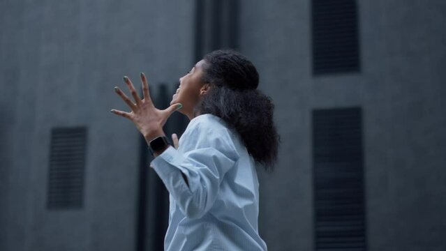 Happy woman celebrating success at office building alone. Overjoyed student jump