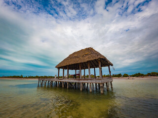Panoramic view of the fisherman's pier on Holbox Island and a fishing boat on the tropical beach