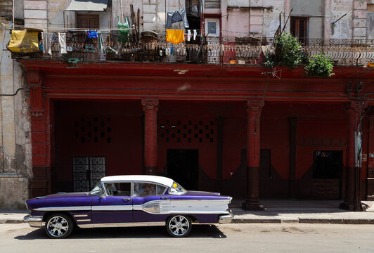 Fototapeta a purple old car with white lines parking on the street