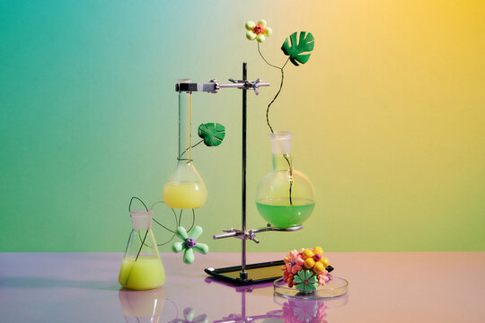 Assorted laboratory glassware equipment showcase with leaves on colorful background. 