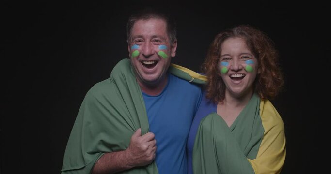 Brazil fan couple, Soccer fans, smiling and giving a kiss, world cup, black background. World Cup, Olympics