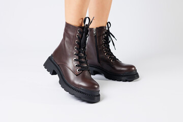 Women's brown spring boots made of genuine leather on a woman's leg. New collection of women's boots 2022
