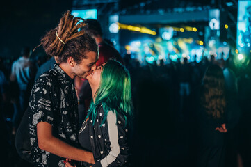 Young happy couple kissing at music festival