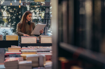 Woman choosing vinyl record in music record shop