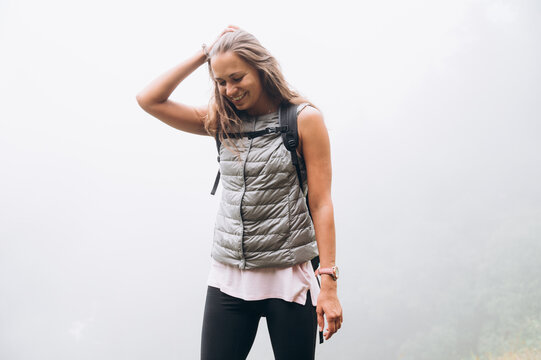 Happy female hiker smiling against misty background