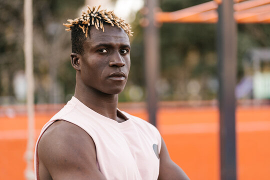 Self confident black athlete on sports ground