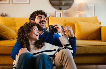 Dog licking happy owners in living room