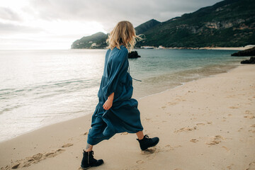 Woman walking along the sea during sunset