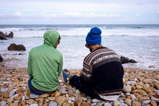 Two young men hanging out on a beautiful beach