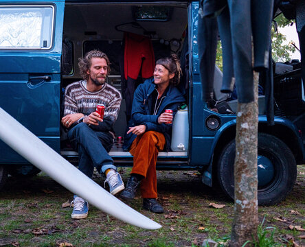 Two surfers chilling in their Campervan after a surf session 