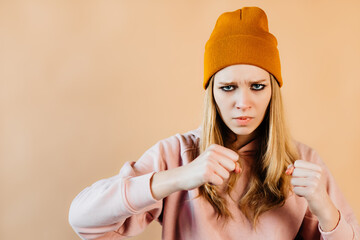 Beautiful girl is posing with her wrists in a fighting stance. The girl is preparing for her box...