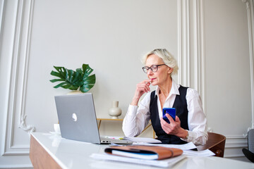 Mature woman accountant considers the budget,
