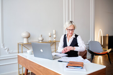 Adult woman boss checks watches,