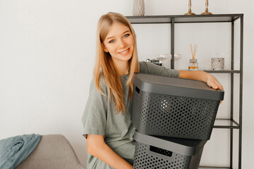 Young woman is holding the boxes and looking straight at the camera. The girl is smiling and looks excited because she is moving into another apartment. Concept of moving