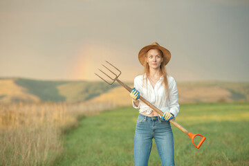Country woman in field with pitchfork. Harvest festival