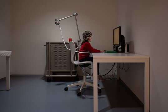 Child in EEG cap looking at monitor in laboratory