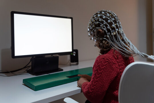 Kid in EEG cap looking at monitor in laboratory