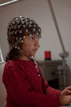 Child in EEG cap looking at monitor in laboratory
