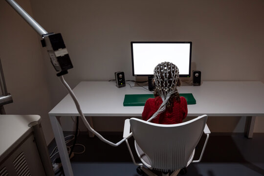 Kid In EEG Cap Looking At Monitor In Laboratory