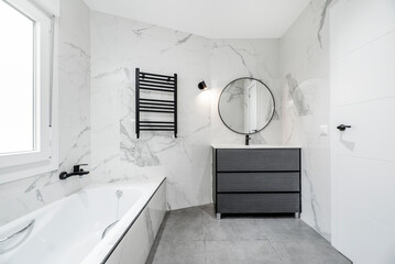 Bathroom with a white porcelain sink on a black wooden countertop, gray stoneware walls and red...